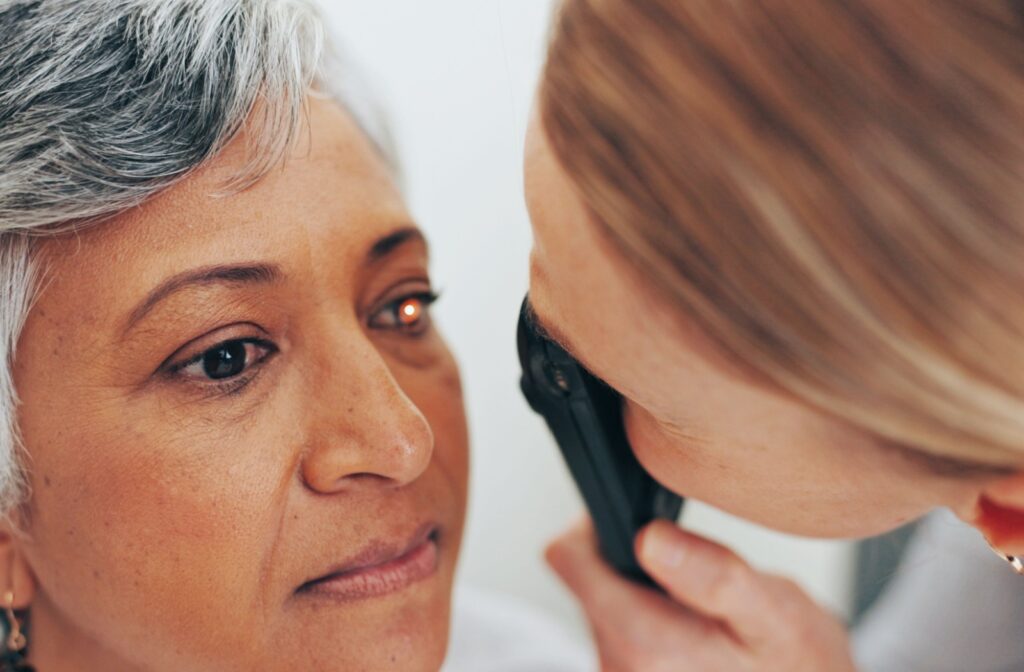 An eye doctor uses an ophthalmoscope to examine a patient's retinal health.