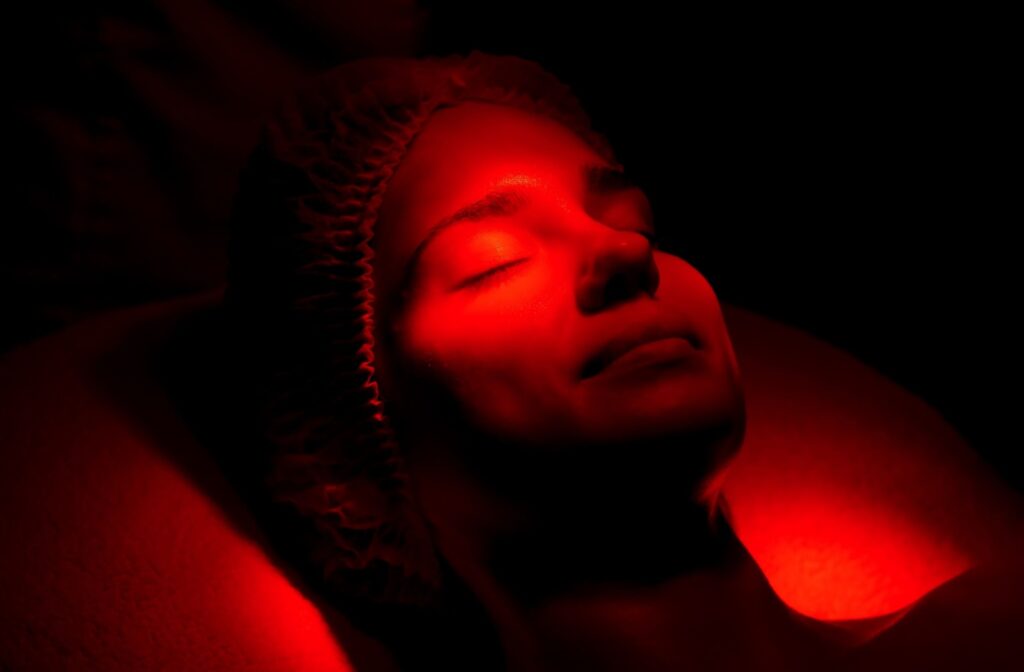 Adult relaxing while receiving a red light therapy treatment for their rosacea